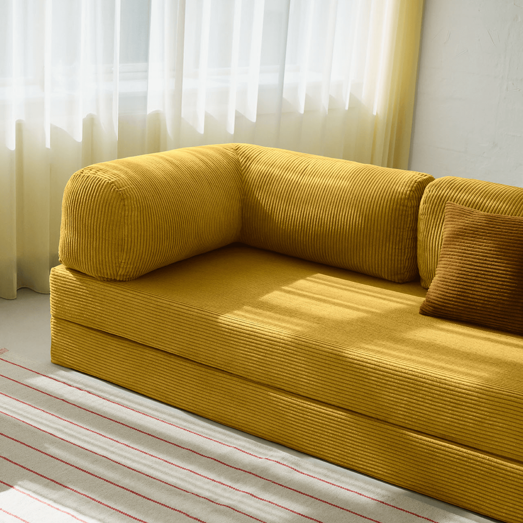 Primyhome Ginger Yellow corduroy convertible sofa bed in a sunlit living room with minimalist decor and boho wall art