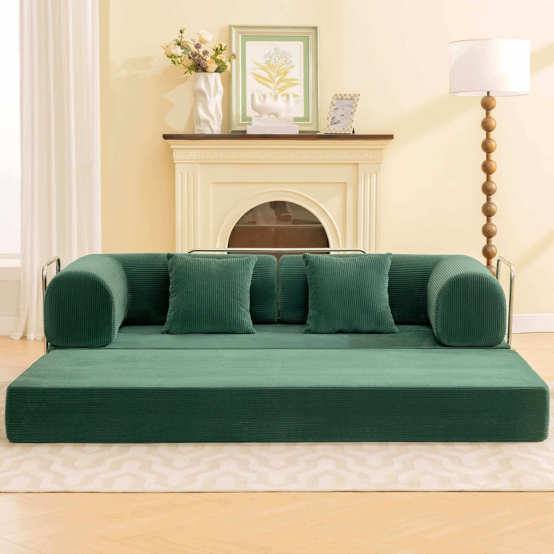 Primyhome Modern convertible green corduroy floor sofa bed in a cozy living room setting with a wooden floor lamp and framed botanical art.